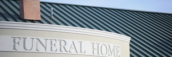 Close up of funeral home sign engraved on curved building front with copy space above