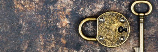 Escape room concept. Web banner of a vintage gold key and locked padlock on a rusty metal background.