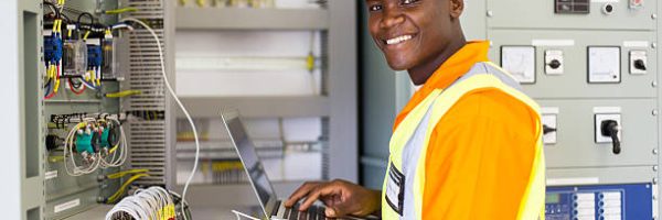 african electrical worker using laptop computer checking transformer