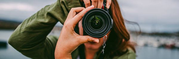 A young woman using a DSLR camera